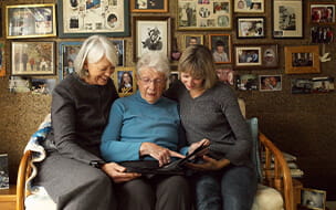 Three Generations of Women Looking at Photo Album