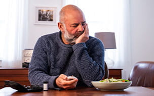 An upset diabetic male patient testing his blood sugar at home