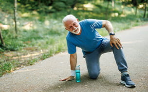 Senior man runner with knee pain in the park