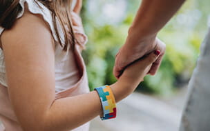 Autistic child holding hands with her mother