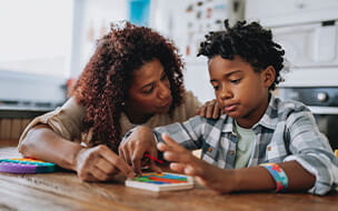 Mother playing with autistic son at kitchen table