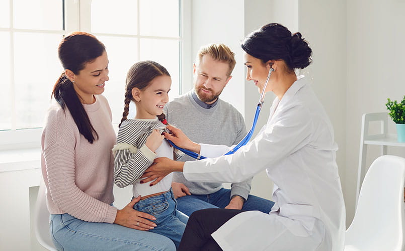 A happy family visits their primary care doctor
