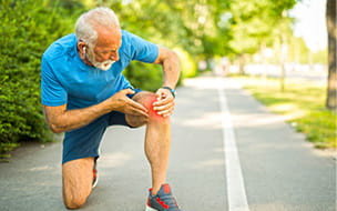 Senior male holding knee