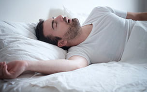 Male asleep with arm stretched out