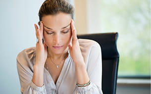 Woman showcasing a headache while holding temples