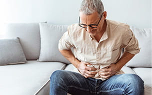 Mature man suffering from stomachache at home
