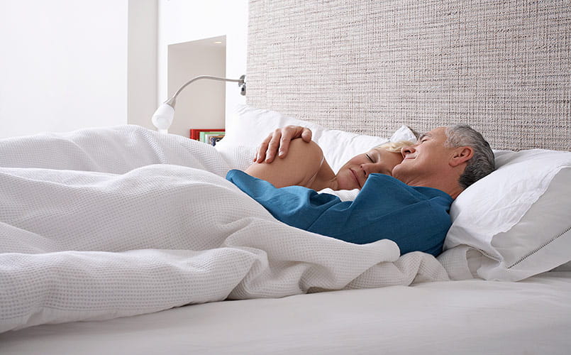 Middle aged couple sleeping in bed