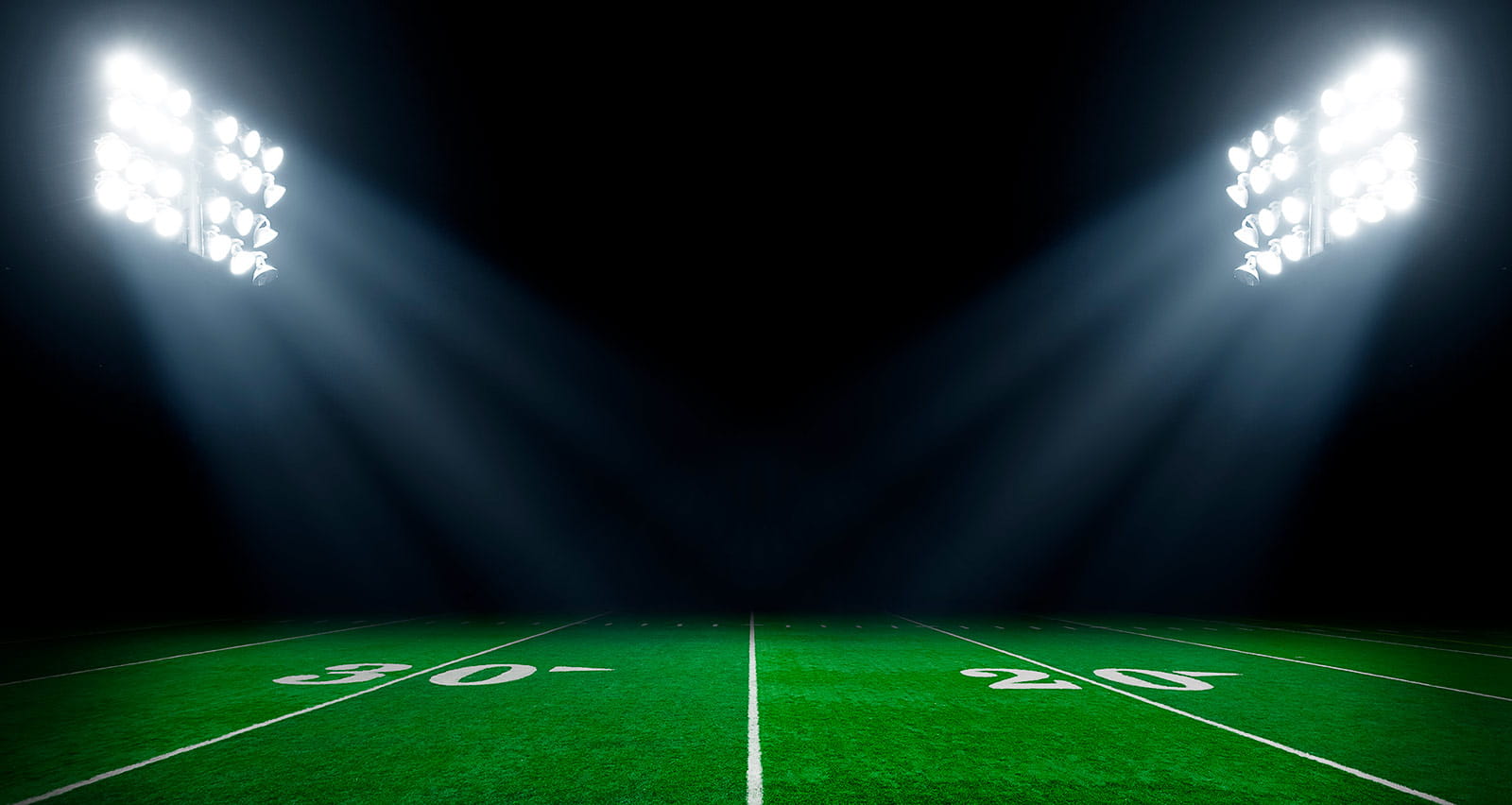Football field at night with stadium lights