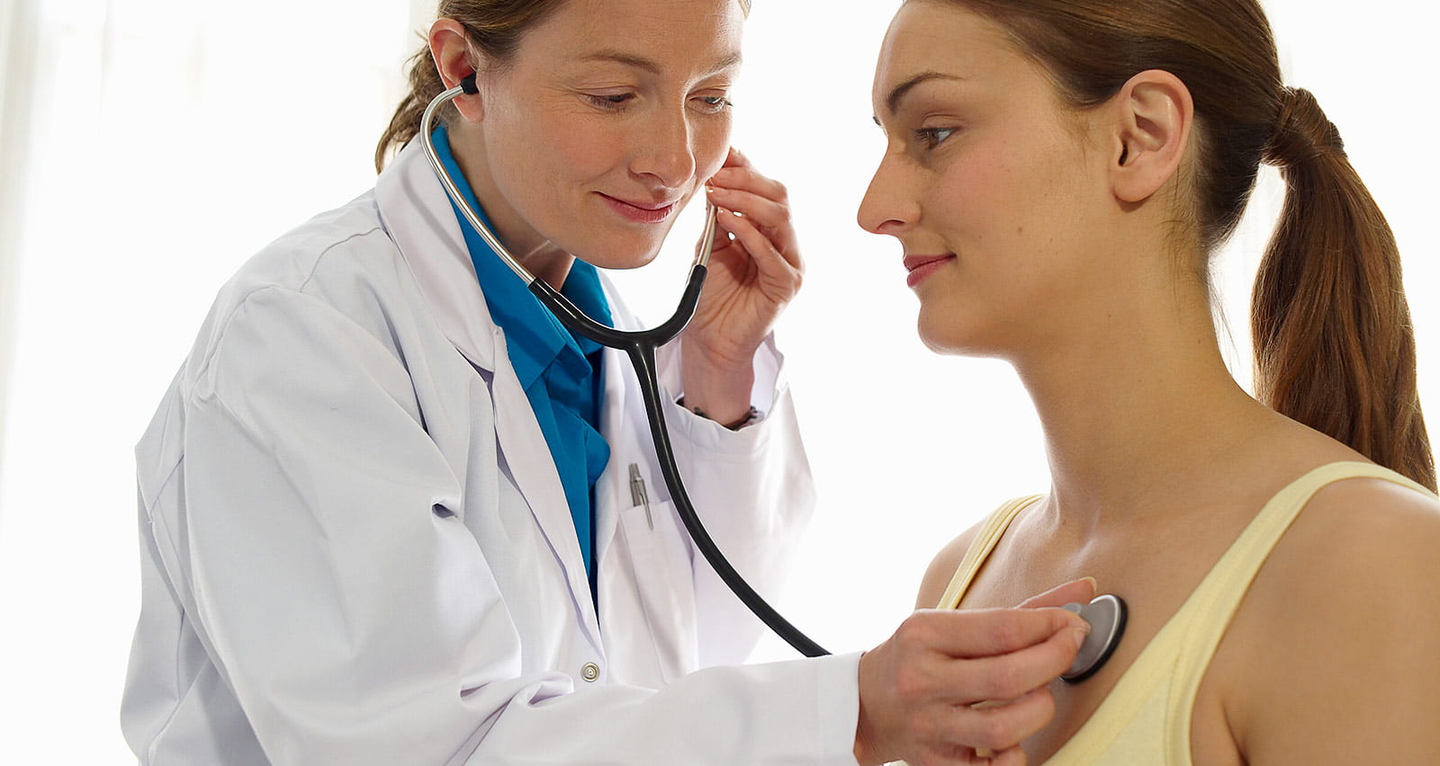 Female doctor using stethoscope on a patient