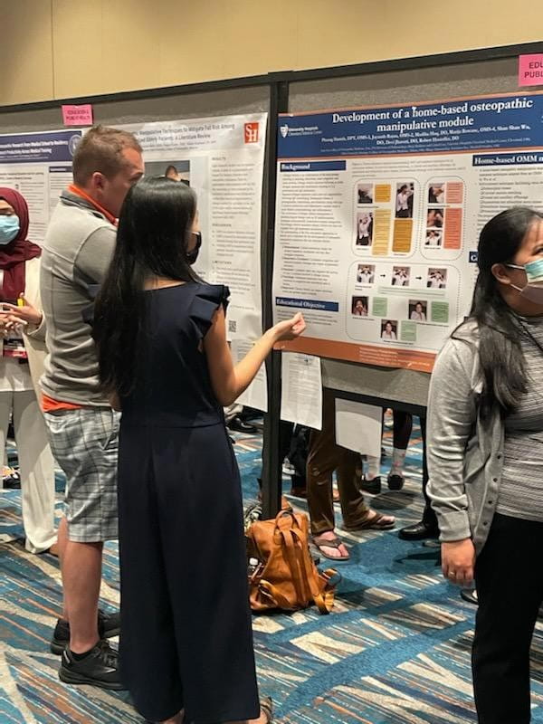 osteopathic student with research poster