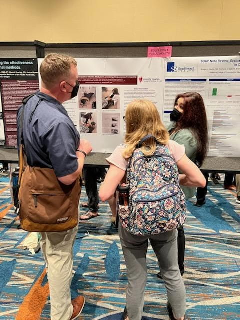 osteopathic student with research poster