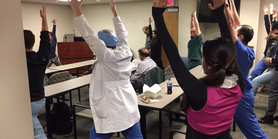 Residents standing in a group with arms above their heads