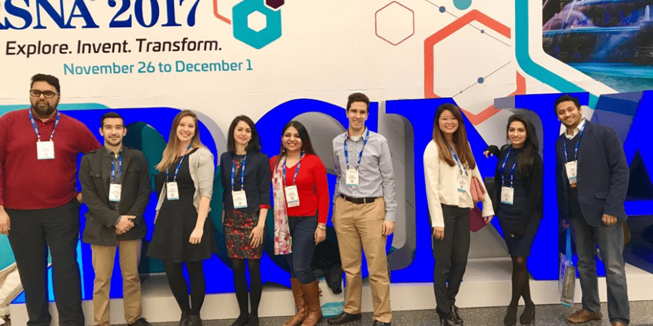 Group of residents standing in a row in front of RSNA sign