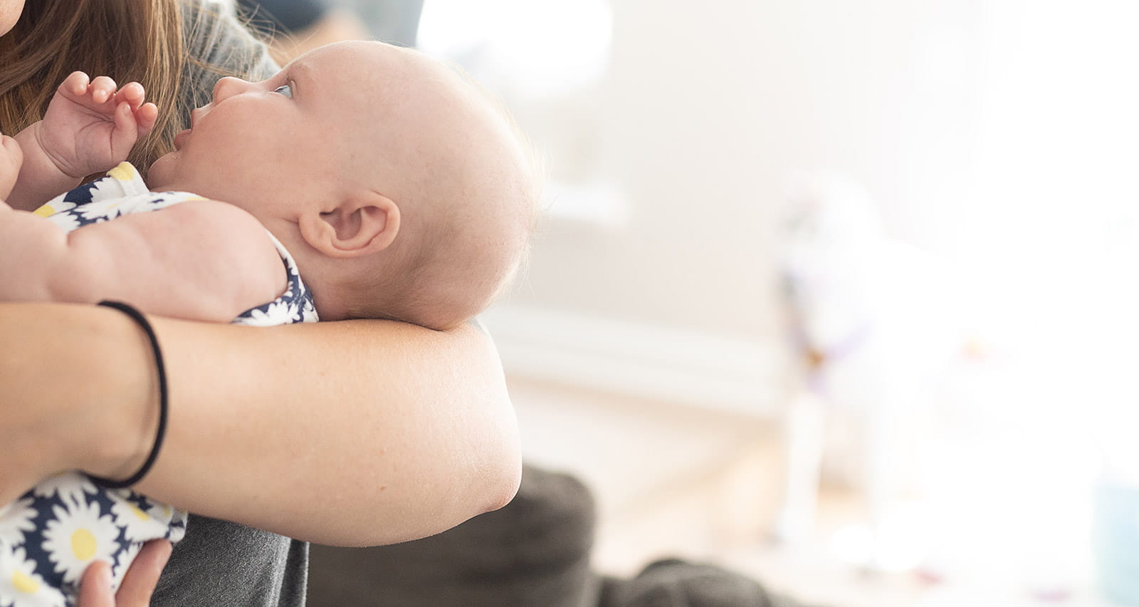 An infant is held by its mother
