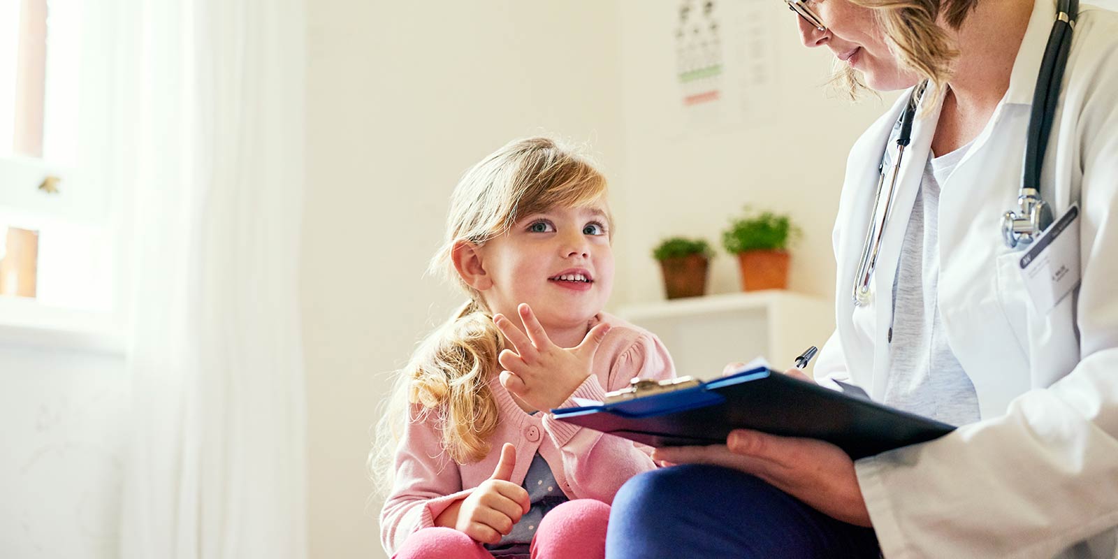 physician with child taking notes