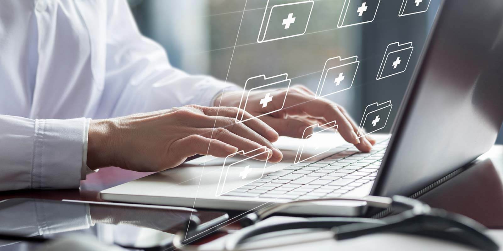 Doctor working on laptop with electronic documents