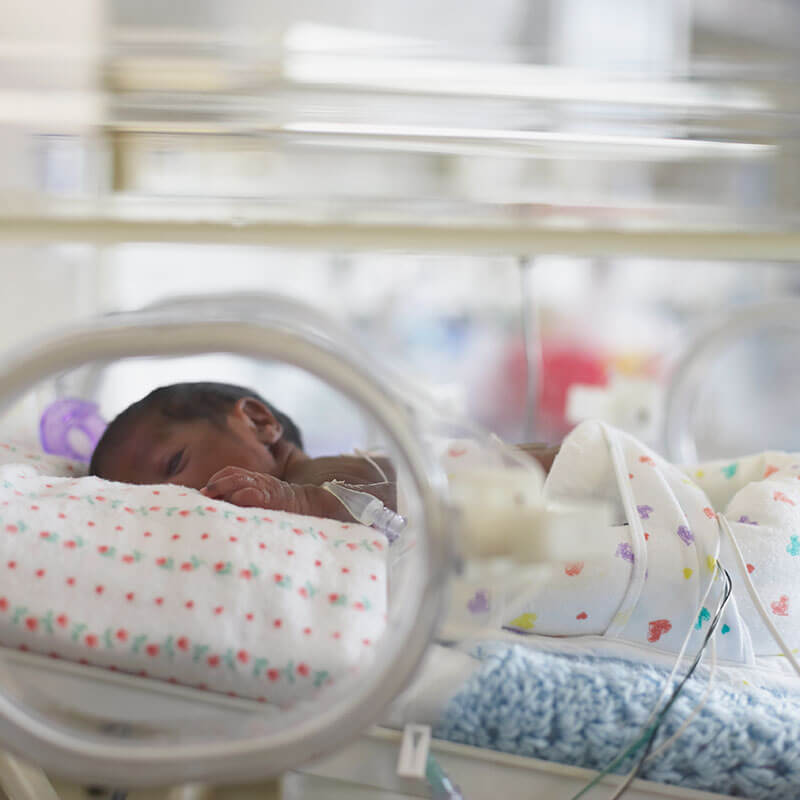 African American baby in hospital incubator