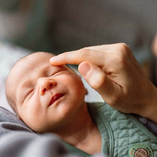 father touching baby's forehead