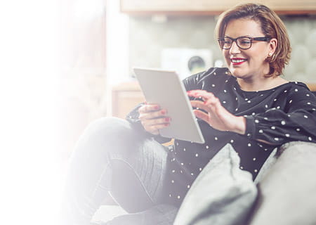 Woman seated looking at tablet computer