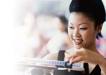 Smiling woman standing on a scale