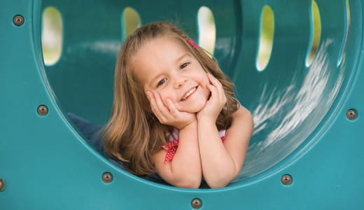 Girl inside a playground tunnel.