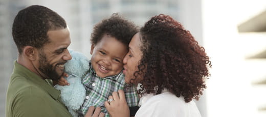 Mother & father holding child.
