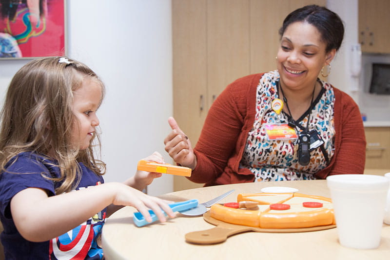 Rainbow Babies & Children’s Hospital lab nurse working with girl