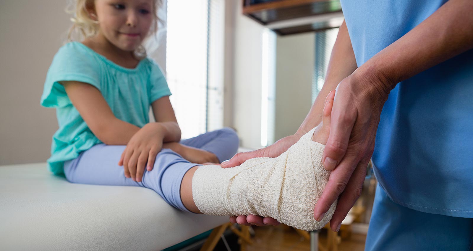 Nurse bandaging a child's leg