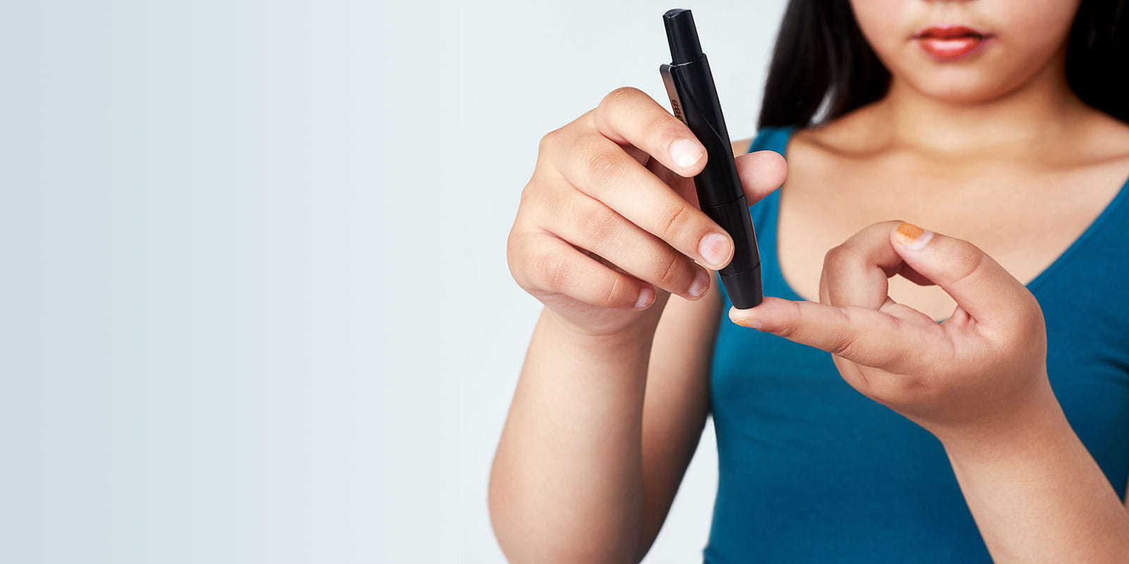 A young girl using a blood sugar test on her finger