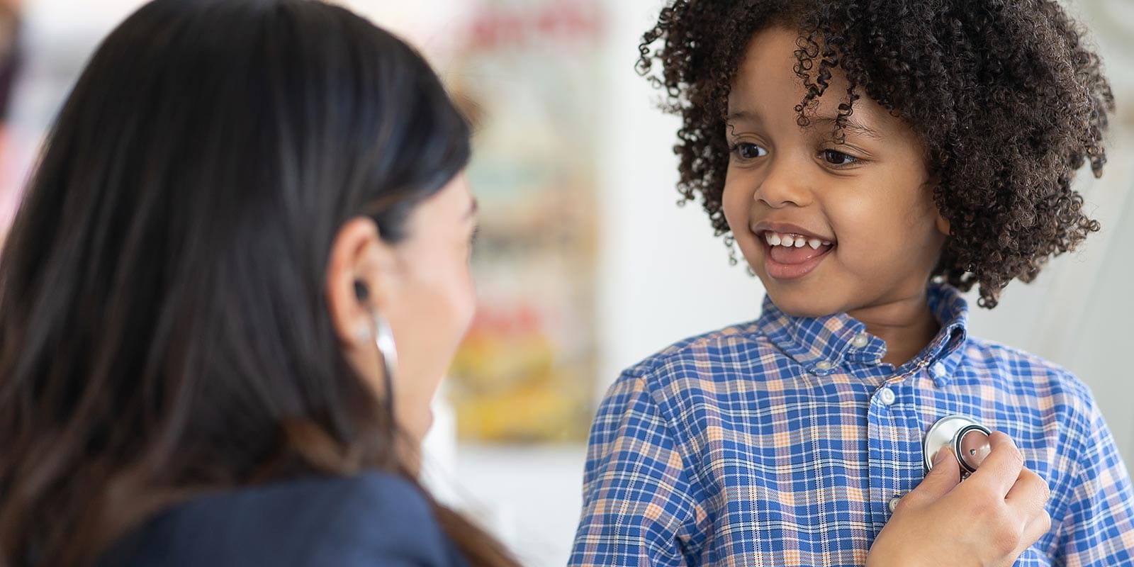 A doctor is checking a young boy's heart rate with a stethoscope