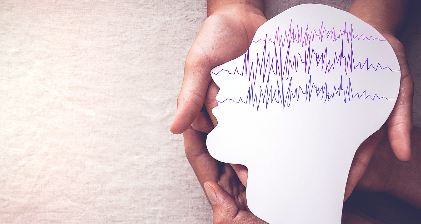 Adult and child hands holding encephalography brain paper cutout