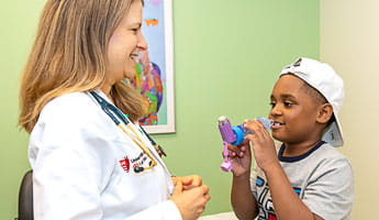 UH provider looks on as child operates breathing device