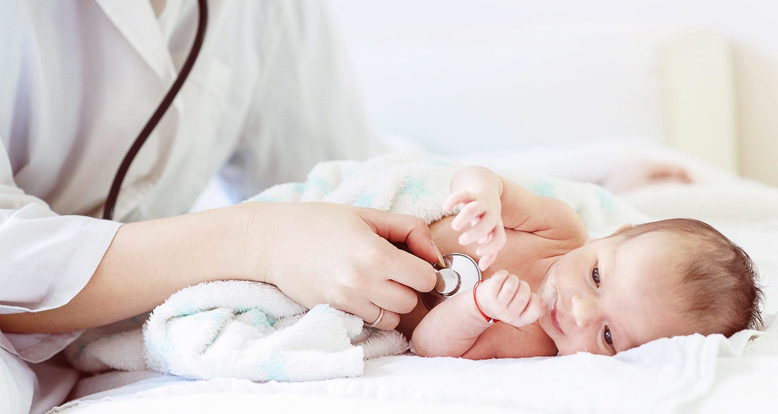 Female doctor examines infant with stethoscope