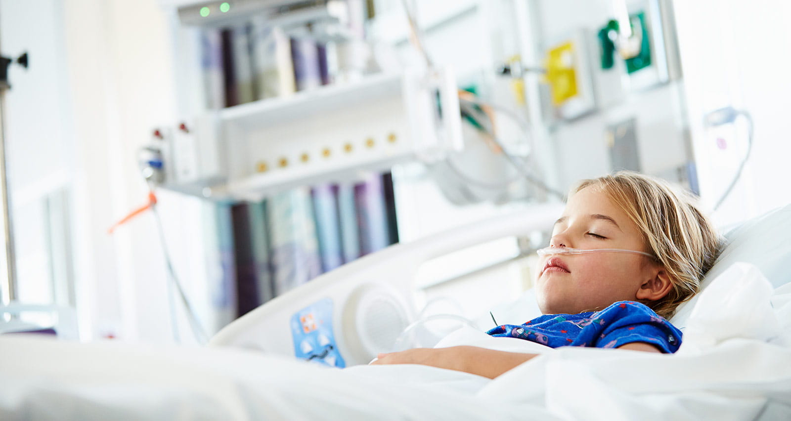 A young girl is asleep in a hospital bed