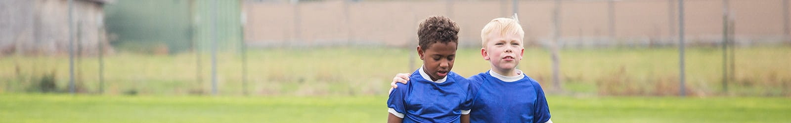 Children walking off the soccer filed together.