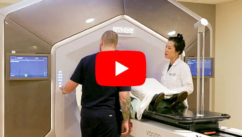 Angela Jia, MD, PhD assists a patient through the Varian Ethos therapy system at UH Seidman Cancer Center