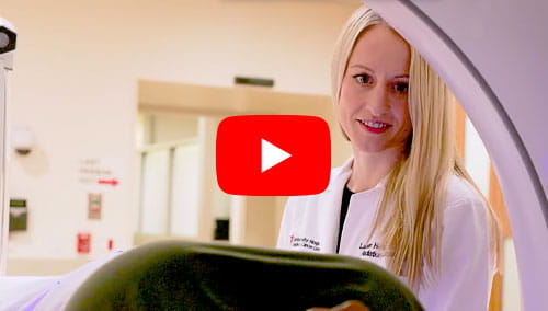 Lauren Henke, MD assists a patient through the Varian Ethos therapy system at UH Seidman Cancer Center