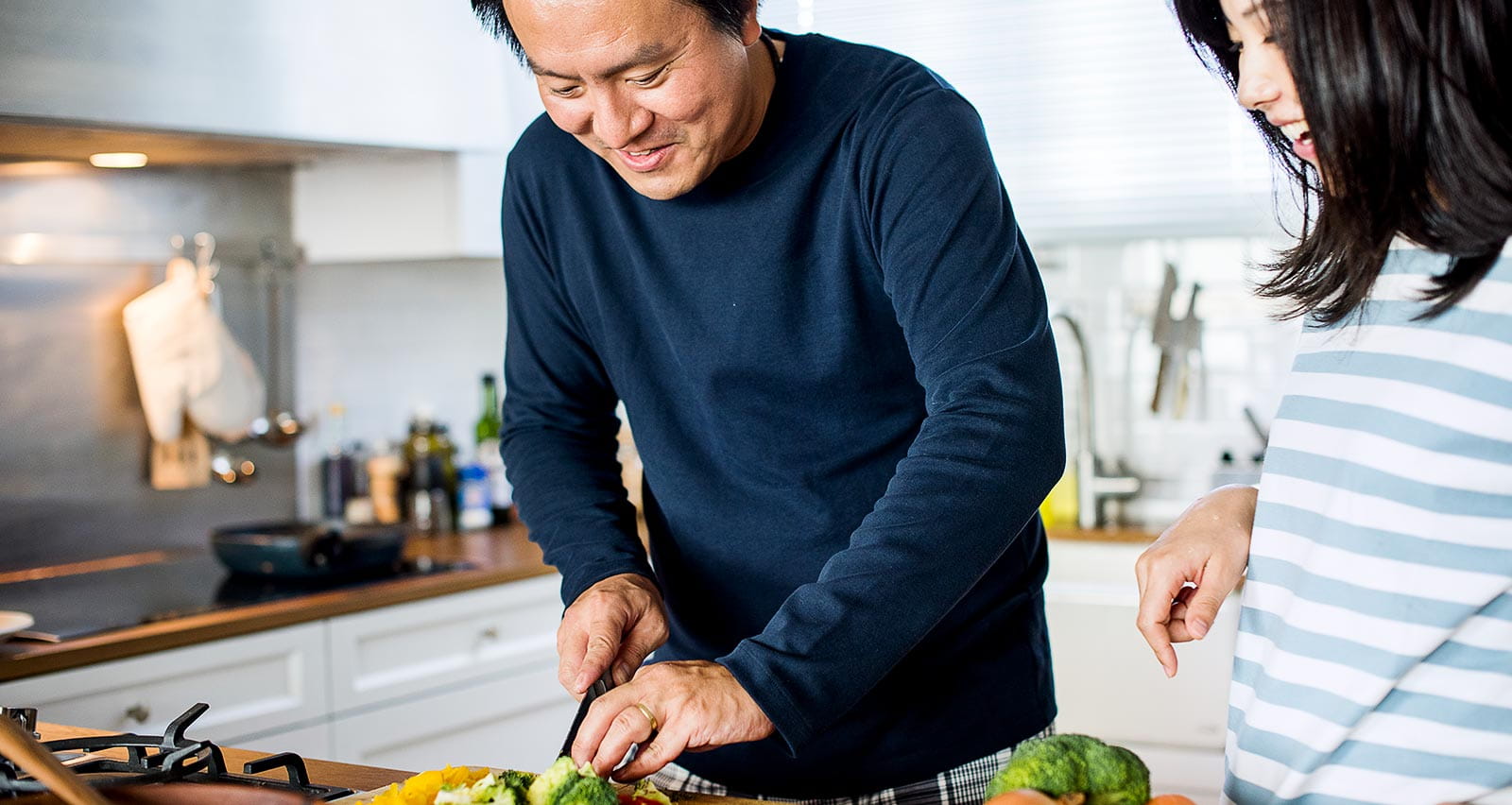 An Asian couple is cooking in their kitchen
