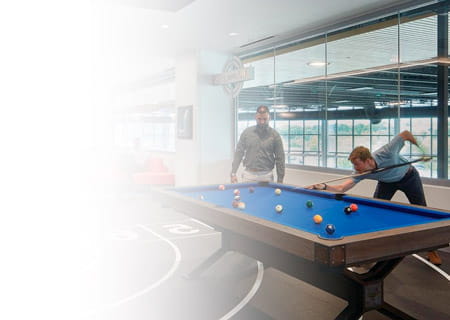 Two men playing billiards at UH Ahuja Medical Center