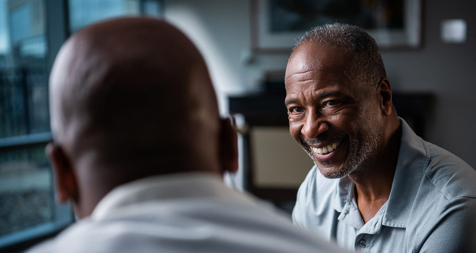 A smiling older man consulting with his physician