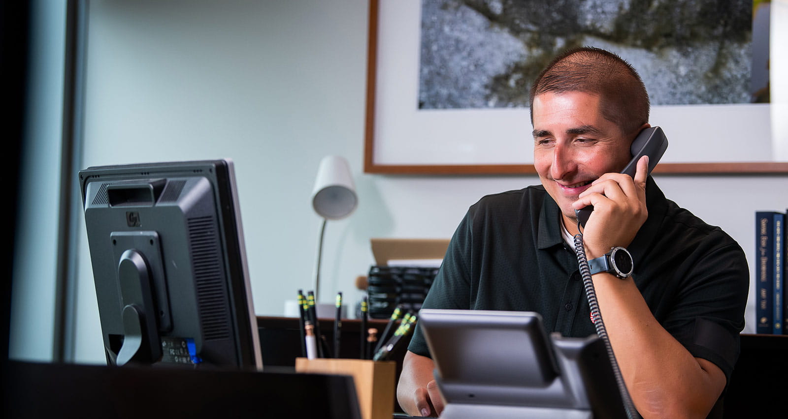 A man in his home office making a telephone call