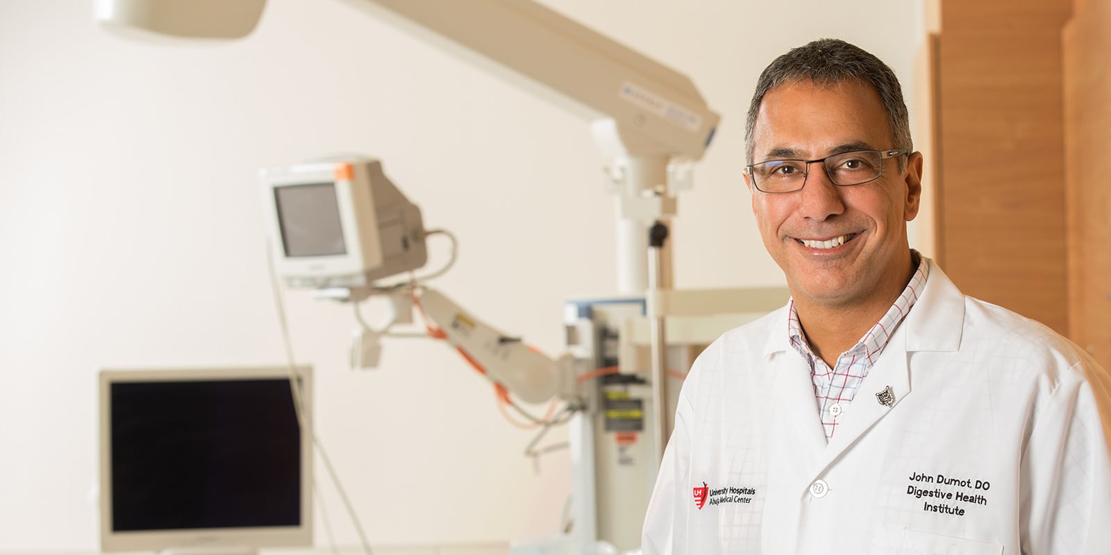 Dr. John Dumot standing in front of medical equipment.