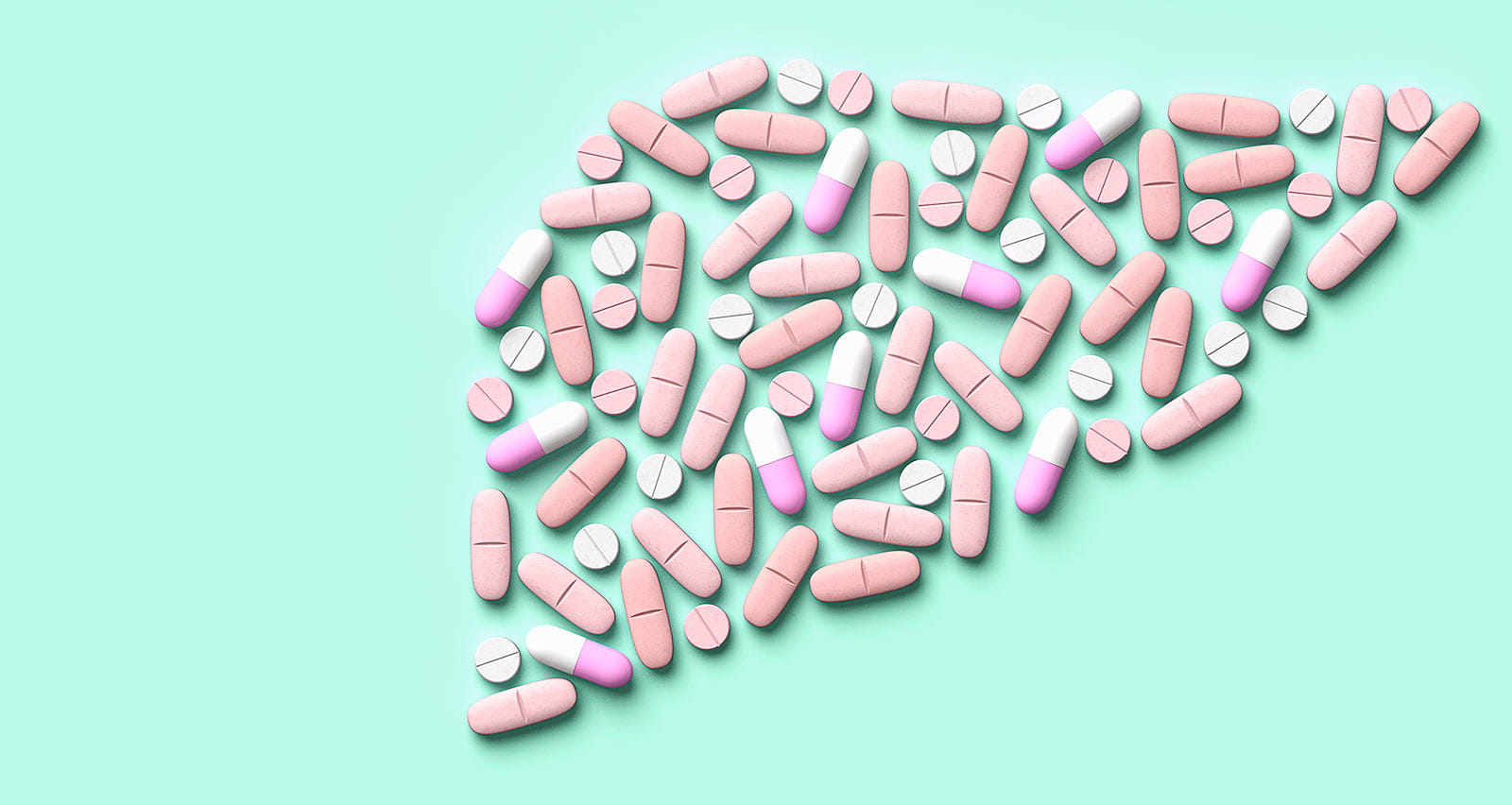 Pills and capsules arranged in the shape of a human liver