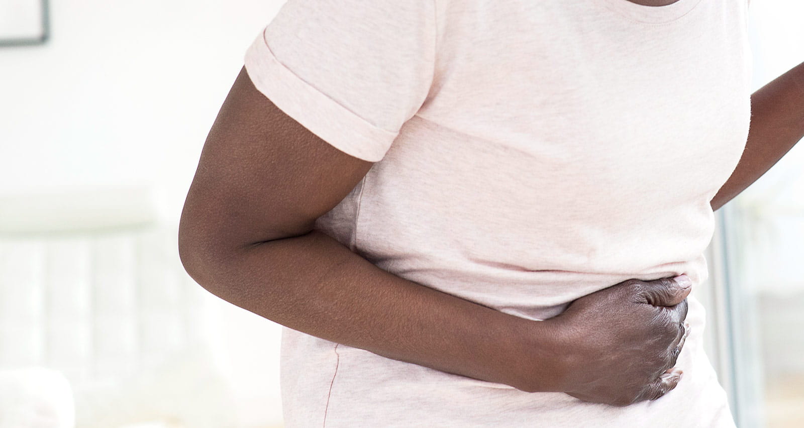 Mature woman grasping her stomach in pain