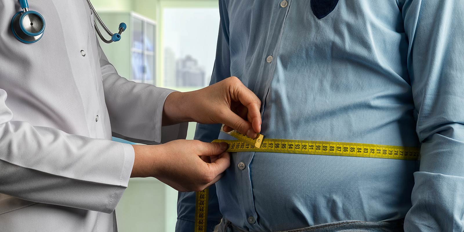 Physician measuring man's stomach