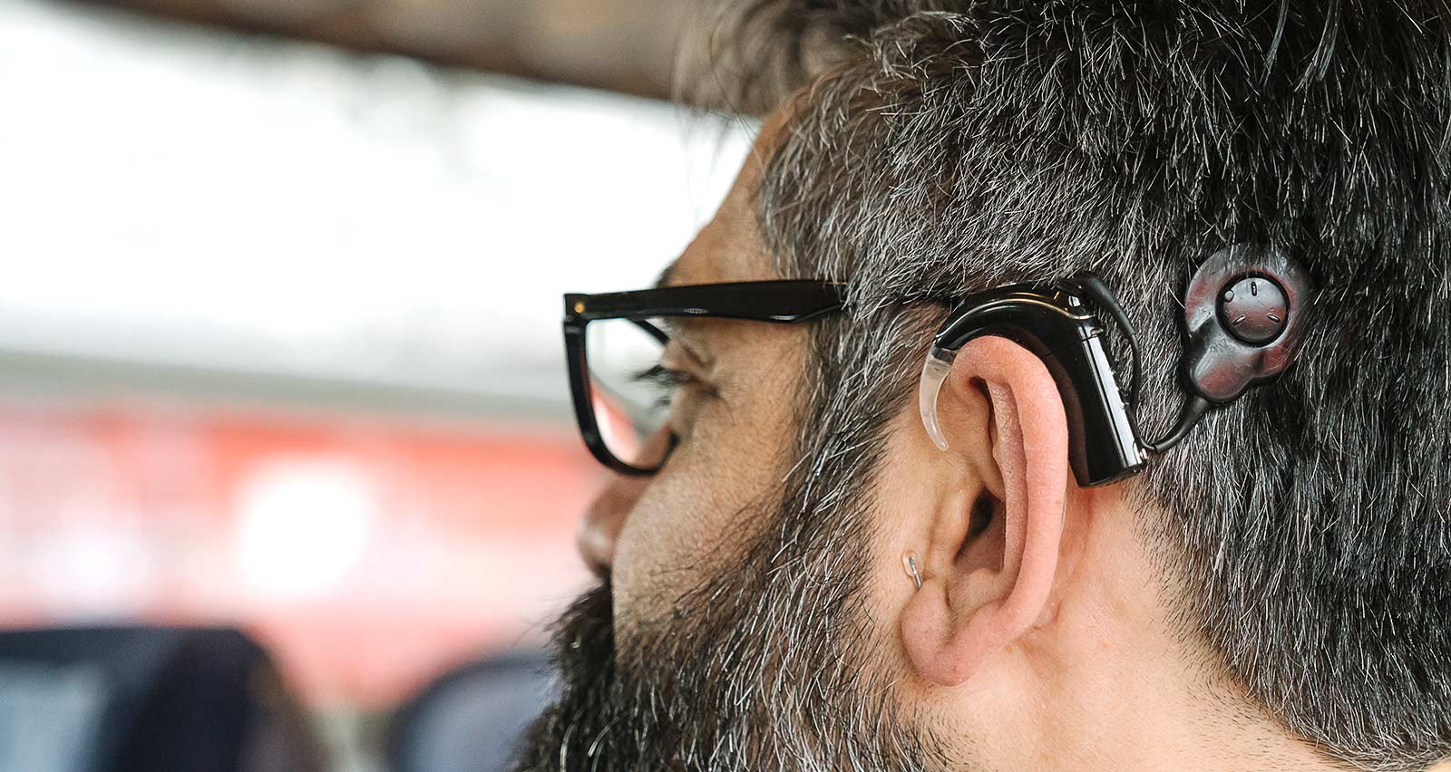 Profile of a man with cochlear implant in a train