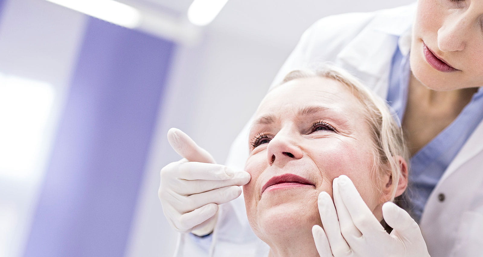 A female doctor examining patient’s face