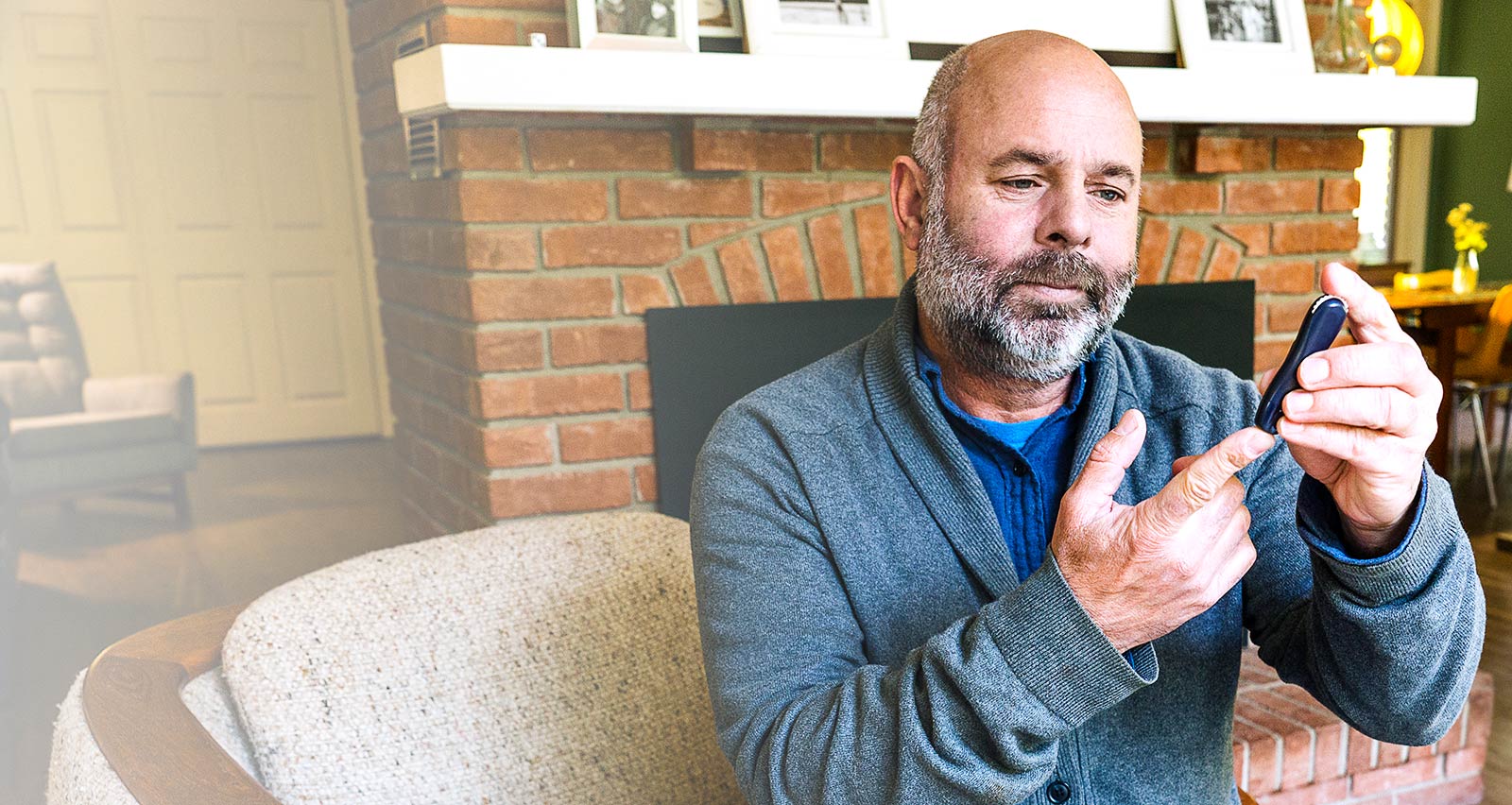 A mature man in his fifties at home testing his blood sugar levels