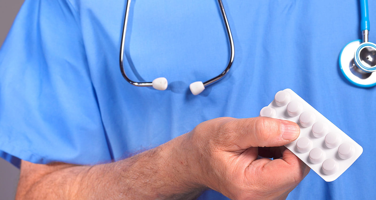 A doctor offering a packet of statin tablets