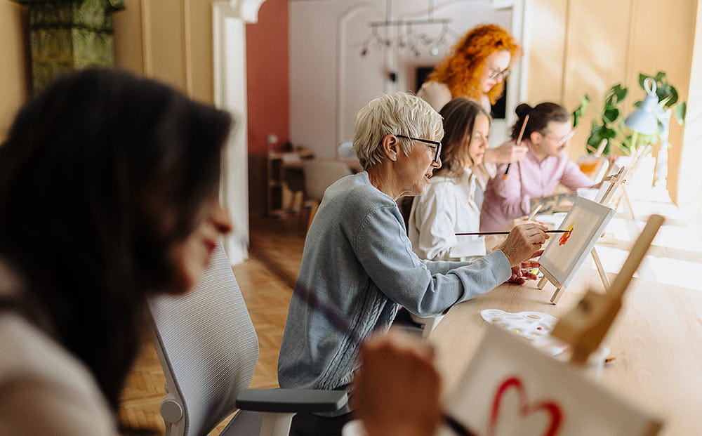 A group participates in therapy painting